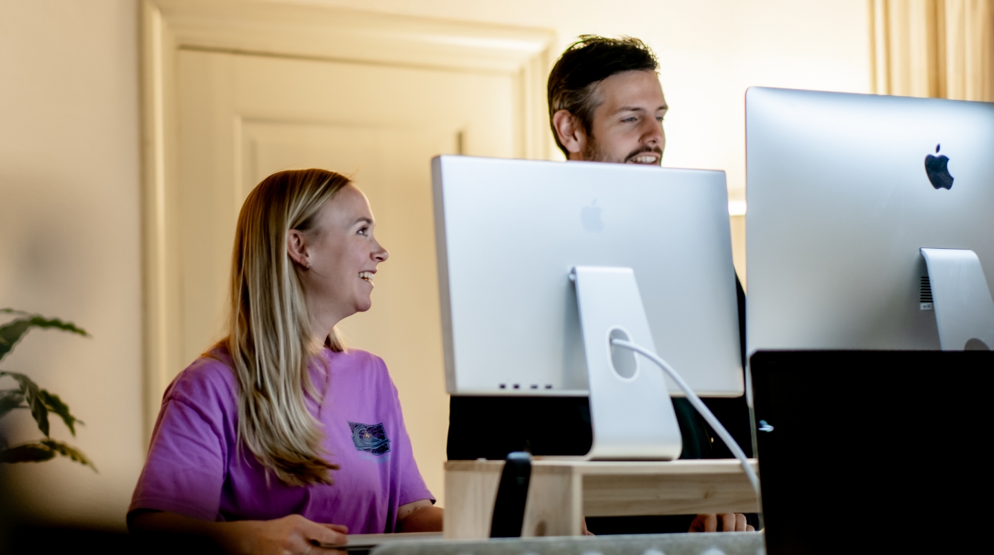 Twee mensen werken samen achter een computer.