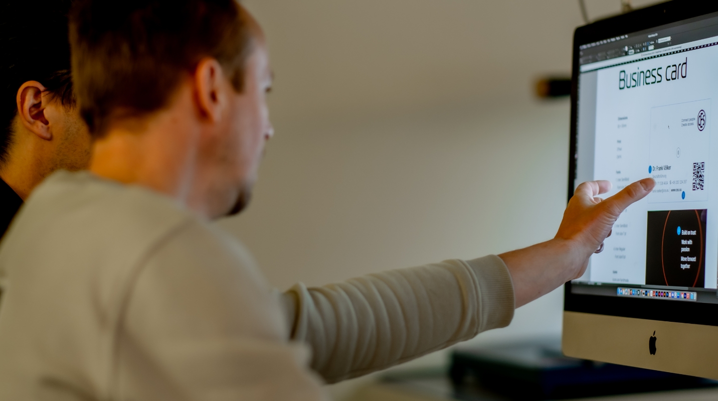 Twee mannen werken aan een ontwerp op een computer.