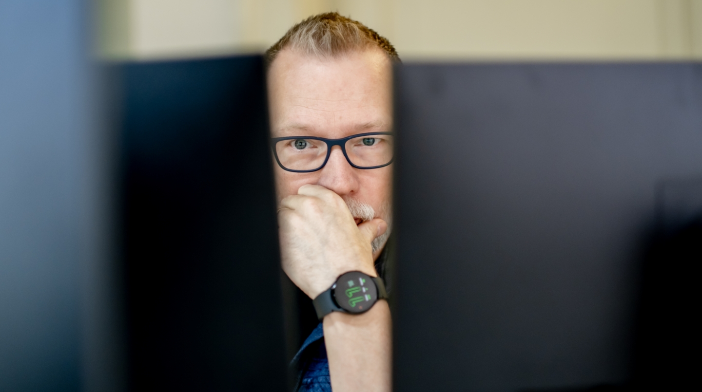 Patrick kijkt geconcentreerd naar computerschermen.