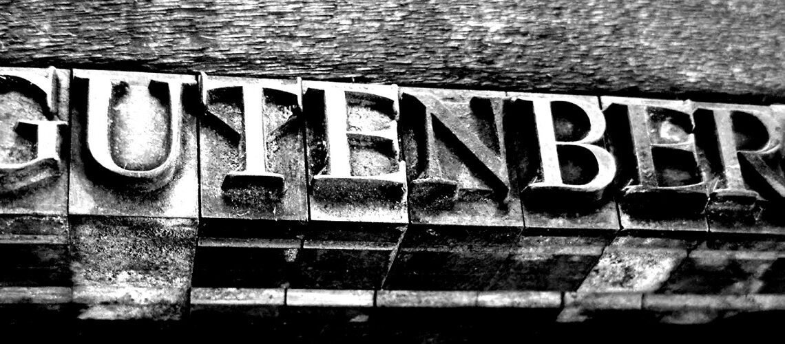 Close-up van metalen drukletters met het woord 'Gutenberg'.
