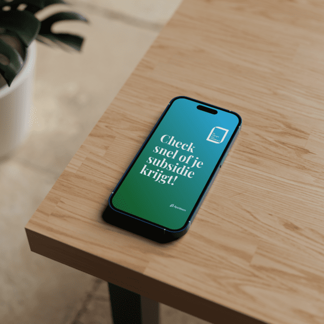 Smartphone op houten tafel met campagneboodschap: 'Check snel of je subsidie krijgt!'