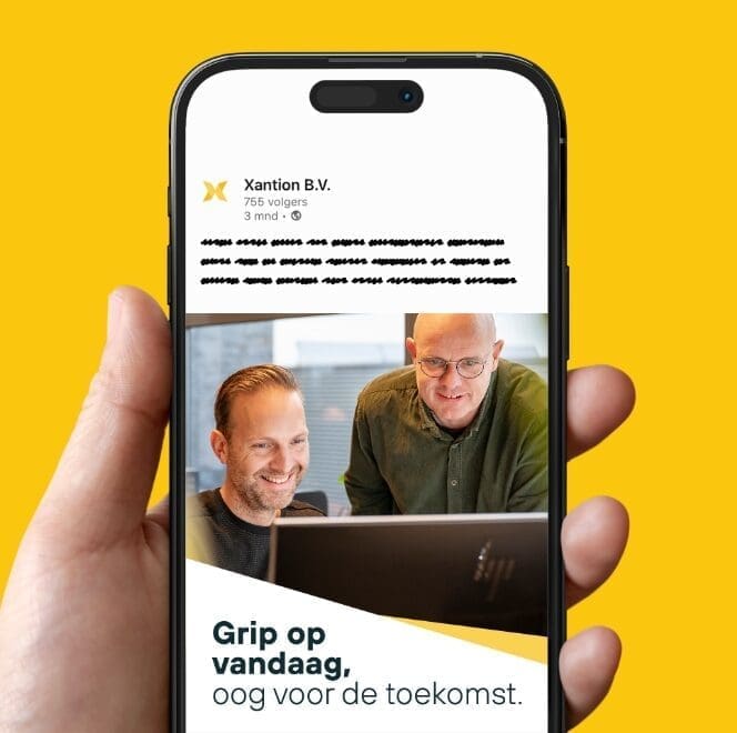 Twee medewerkers van Xantion ICT kijken lachend naar een computerscherm, met op de achtergrond de tekst: 'Grip op vandaag, oog voor de toekomst'.